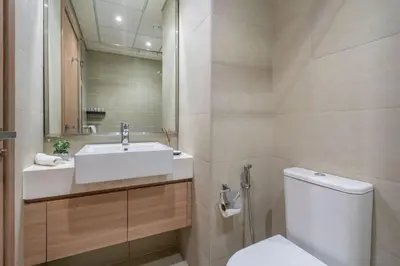 a bathroom with a sink and a toilet and a mirror at GuestReady - Downtown Dubai luxurious living in Dubai