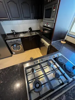 a kitchen with a stove top oven in a kitchen at Ashri HH, Studio in JVC in Dubai