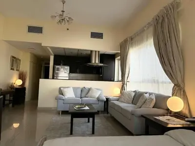 a living room with two couches and a kitchen at Ashri HH, Studio in JVC in Dubai