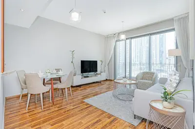 a white living room with a table and chairs at City skyline view I Super-fast Wi-fi I Downtown in Dubai