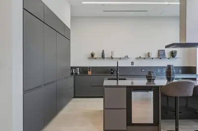 a kitchen with gray cabinets and a kitchen island at Palm Penthouse Sky Villa - Vast Terrace & Jacuzzi by Exclusive Holiday Homes in Dubai