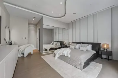 a bedroom with a large bed and a mirror at Palm Penthouse Sky Villa - Vast Terrace & Jacuzzi by Exclusive Holiday Homes in Dubai