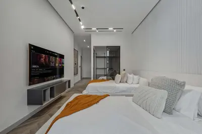 a bedroom with two beds and a flat screen tv at Palm Penthouse Sky Villa - Vast Terrace & Jacuzzi by Exclusive Holiday Homes in Dubai