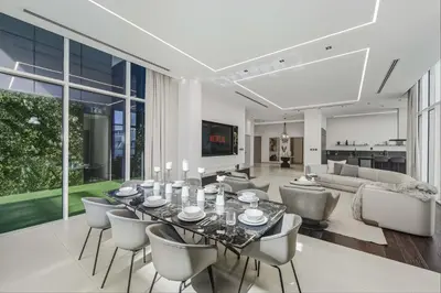 a dining room and living room with a table and chairs at Palm Penthouse Sky Villa - Vast Terrace & Jacuzzi by Exclusive Holiday Homes in Dubai