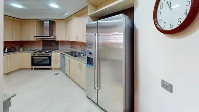 a large kitchen with a large clock on the wall at Dabas Palm Shores Elegant Four Beds in Dubai
