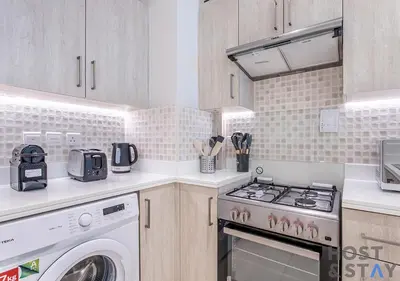 a kitchen with a stove and a washer and dryer at Luxurious 1BR Palm Seven, Palm Jumeirah in Dubai