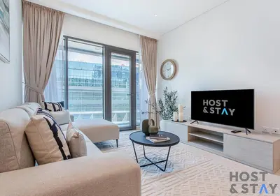 a living room with a couch and a tv at Luxurious 1BR Palm Seven, Palm Jumeirah in Dubai