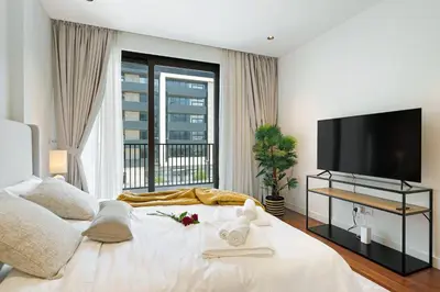 a bedroom with a large bed with a flat screen tv at Experience City Walk - Spacious Haven - 2 Bedroom plus Maid's Room in Dubai