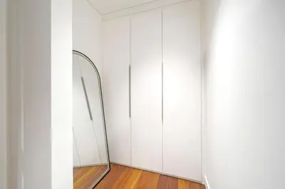 a dressing room with a mirror and white cabinets at Experience City Walk - Spacious Haven - 2 Bedroom plus Maid's Room in Dubai