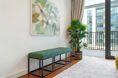 a green bench in a room with a window at Experience City Walk - Spacious Haven - 2 Bedroom plus Maid's Room in Dubai
