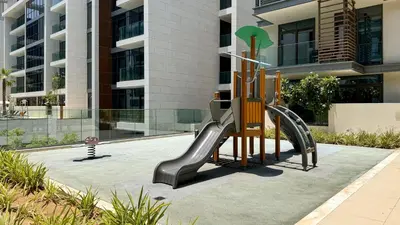 a playground in front of a building with a slide at Experience City Walk - Spacious Haven - 2 Bedroom plus Maid's Room in Dubai