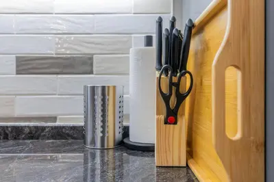 a pair of scissors in a holder next to a roll of paper at Nice studio in Al Furjan - Dubai in Dubai