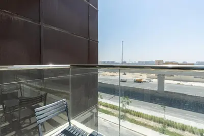 a bench sitting on a building with a view of a highway at Nice studio in Al Furjan - Dubai in Dubai