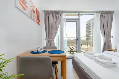a bedroom with a desk and a bed and a window at Nice studio in Al Furjan - Dubai in Dubai