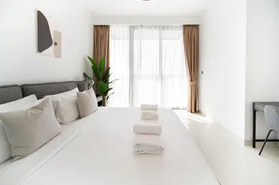 a white room with a bed with towels on it at SettlerHomes - Breathtaking View With Private Beach in Dubai