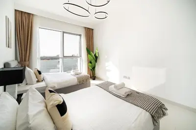 a bedroom with two beds and a chandelier at SettlerHomes - Breathtaking View With Private Beach in Dubai