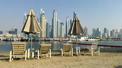 a group of chairs and umbrellas on a beach at Beachfront 2-BDR, High floor, Sea and Palm View, Beach Access in Dubai