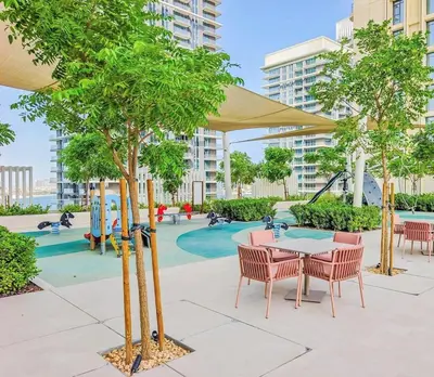 a playground with tables and chairs and trees at Beachfront 2-BDR, High floor, Sea and Palm View, Beach Access in Dubai