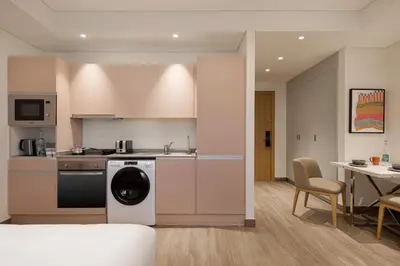 a kitchen with a washing machine and a table with chairs at Rove JBR in Dubai