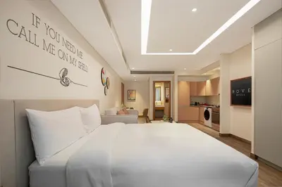 a bedroom with a large white bed and a living room at Rove JBR in Dubai