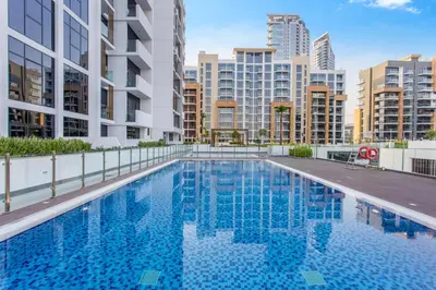 a swimming pool on the roof of a building with tall buildings at Elegant 1BR Retreat in Riviera 36 Near Downtown in Dubai