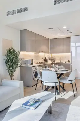 a kitchen and living room with a table and chairs at Elegant 1BR Retreat in Riviera 36 Near Downtown in Dubai