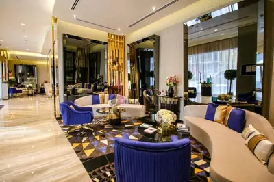 a hotel lobby with couches and blue chairs at GLOBALSTAY DAMAC Majestine Apartments in Dubai