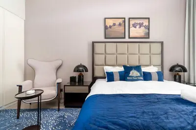a bedroom with a king sized bed and a chair at GLOBALSTAY DAMAC Majestine Apartments in Dubai