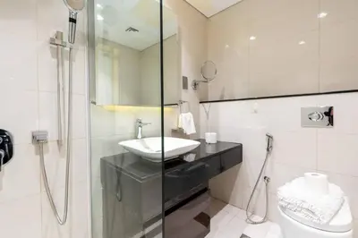 a bathroom with a sink and a glass shower at GLOBALSTAY DAMAC Majestine Apartments in Dubai
