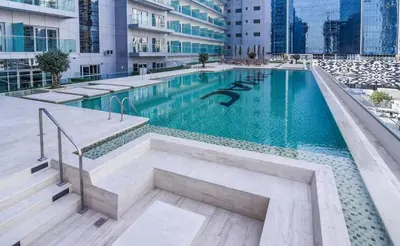 a swimming pool with blue water in a building at GLOBALSTAY DAMAC Majestine Apartments in Dubai