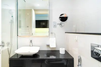 a white bathroom with a sink and a mirror at GLOBALSTAY DAMAC Majestine Apartments in Dubai