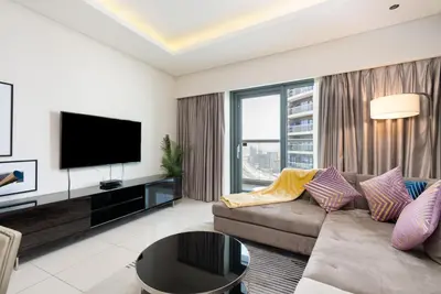 a living room with a couch and a flat screen tv at GLOBALSTAY DAMAC Majestine Apartments in Dubai