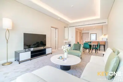 a living room with a couch and a tv at Iconic One Bedroom Panoramic Palm Views in Dubai