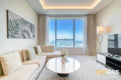 a living room with a couch and a table at Iconic One Bedroom Panoramic Palm Views in Dubai