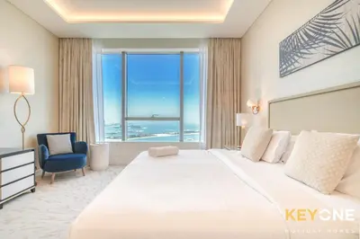 a bedroom with a large bed with a large window at Iconic One Bedroom Panoramic Palm Views in Dubai
