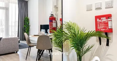 a dining room with a table and some plants at Stunning Luxury 1BR - Modern with Pool View - JVC in Dubai