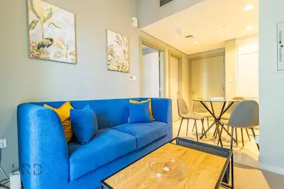 a blue couch in a living room with a table at Cozy & Radiant 1BR Business Bay in Dubai