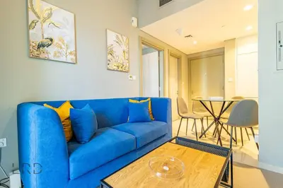 a blue couch in a living room with a table at Cozy & Radiant 1BR Business Bay in Dubai
