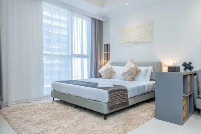 a bedroom with a bed and a large window at Escape24 Cozy 1BR near Dubai Malll & Burj Khalifa in Dubai