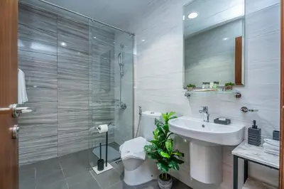 a bathroom with a sink and a toilet and a mirror at Escape24 Cozy 1BR near Dubai Malll & Burj Khalifa in Dubai