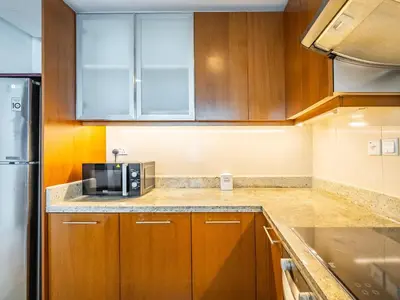 a kitchen with wooden cabinets and a microwave at Downtown Luxury Living -1BR-Standpoint Tower A in Dubai