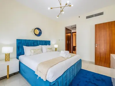 a bedroom with a large bed with a blue headboard at Downtown Luxury Living -1BR-Standpoint Tower A in Dubai