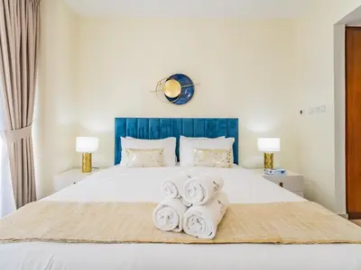 a bedroom with a white bed with towels on it at Downtown Luxury Living -1BR-Standpoint Tower A in Dubai