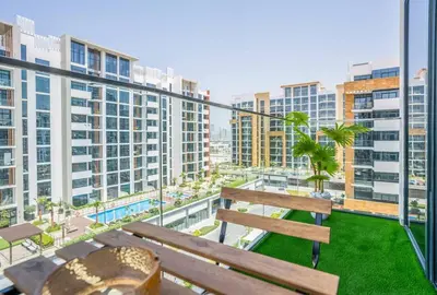 a bench sitting on top of a balcony with buildings at Zapbed House - Modern Studio in Azizi Riviera 27 Meydan One in Dubai