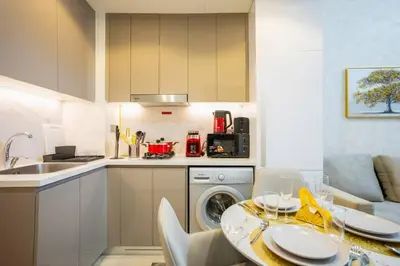 a kitchen with a table and a dishwasher at Zapbed House - Modern Studio in Azizi Riviera 27 Meydan One in Dubai