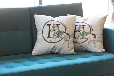 two pillows with a horse on them on a couch at Iconic Burj Khalifa Views from Luxury 1BR Home in Dubai