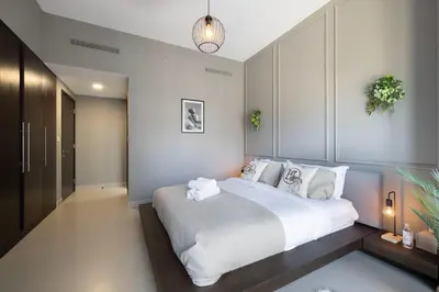 a bedroom with a large bed with white sheets and pillows at Iconic Burj Khalifa Views from Luxury 1BR Home in Dubai