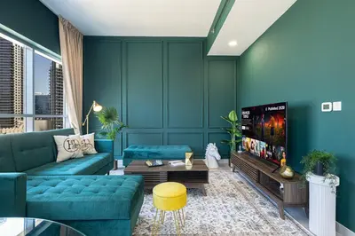 a living room with a blue couch and a tv at Iconic Burj Khalifa Views from Luxury 1BR Home in Dubai