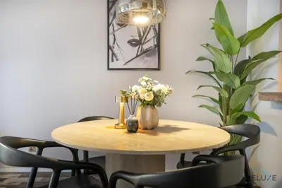 a wooden table with a vase of flowers on it at Charming 1BR in Damac Heights, Dubai Marina by Deluxe Holiday Homes in Dubai