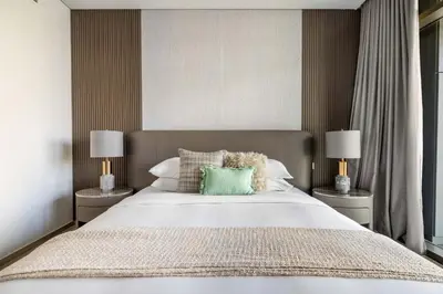 a bedroom with a large bed with two lamps at GuestReady - Upscale living at Palace Residence in Dubai